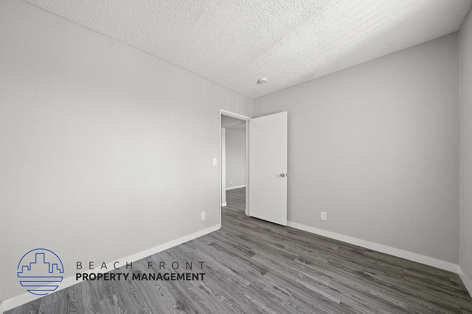 A room with a door and a logo for Beach Front Property Management.